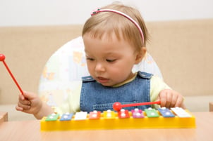 Baby playing toy instrument
