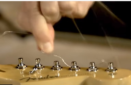 unwind the old strings from the tuning pegs